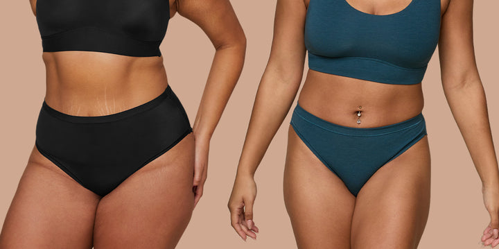 Two models standing side by side against a tan background. The model on the left is wearing the Bliss Highwaist Brief in Black and the model on the right is wearing the Cloud Cotton Bikini in Indigo.