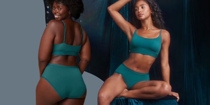 On the left, Akesha smiles while showing the back view of the Bliss Scoop Bralette and Highwaist Brief in Everglade. On the right, Ally poses seated on a velvet backdrop, wearing the Bliss Scoop Bralette and Highwaist Brief in Everglade. She raises one arm above her head, highlighting the bralette’s scoop neckline and the brief’s high-waist fit.