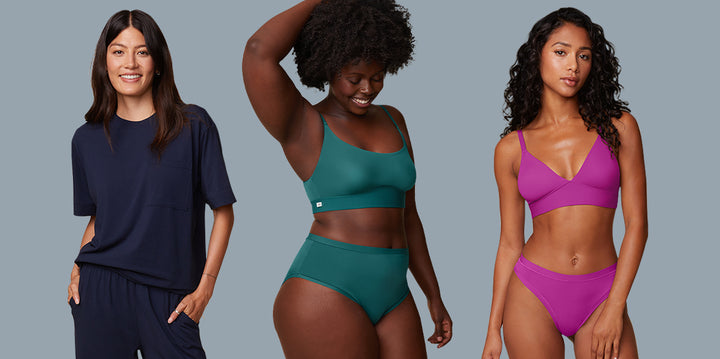 Anna wearing the Perfect Pima T-Shirt and Pant in Navy, Akesha in the Bliss Scoop Bralette and Highwaist Brief in Everglade, and Ally in the Bliss Triangle Bralette and Thong in Berry. All three models stand confidently against a soft blue background.